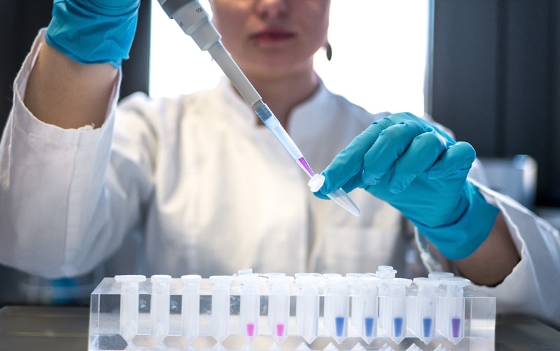 Científicos egipcios de la Universidad de El Cairo crean nanopartículas de oro inteligentes que atacan selectivamente el cáncer de mama sin dañar tejidos sanos 2 Científico usando pipeta en tubos de ensayo en laboratorio - investigación egipcia sobre nanotecnología para tratamiento dirigido del cáncer de mama