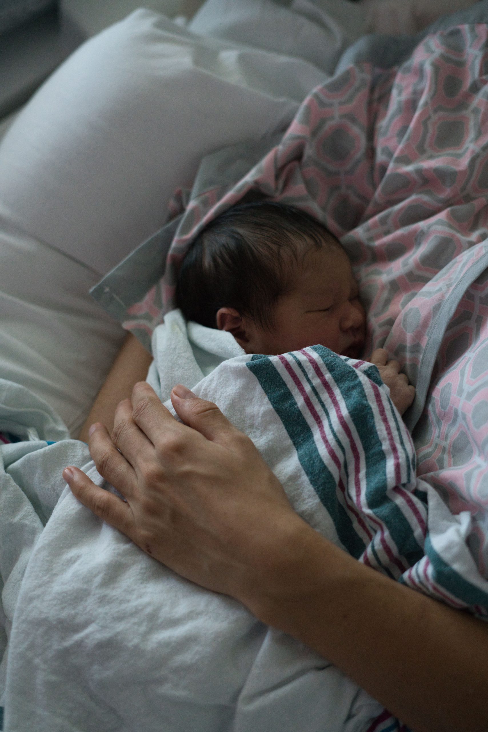 Madre sosteniendo a su bebé recién nacido en una habitación de hospital