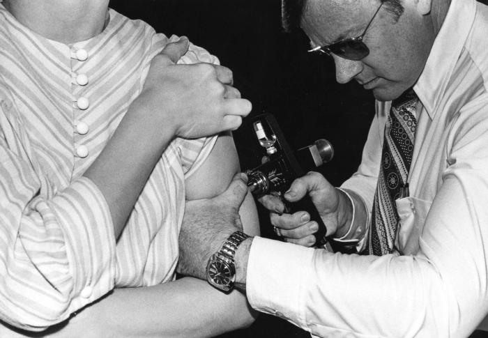 Personal sanitario aplicando una vacuna a un paciente