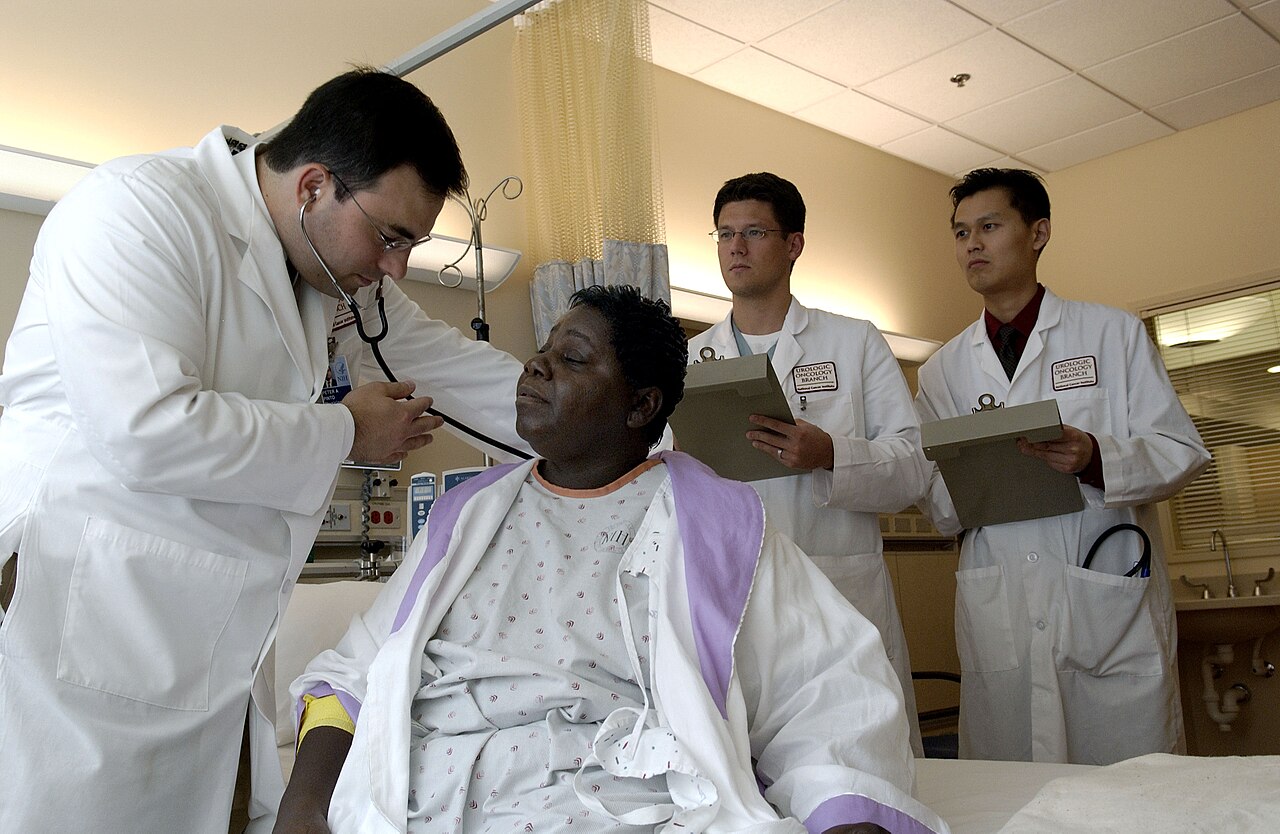 Médico examinando a paciente con estetoscopio en consulta