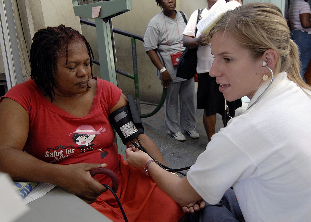 Enfermera toma la presion arterial a un paciente, practica de tamizaje de hipertension